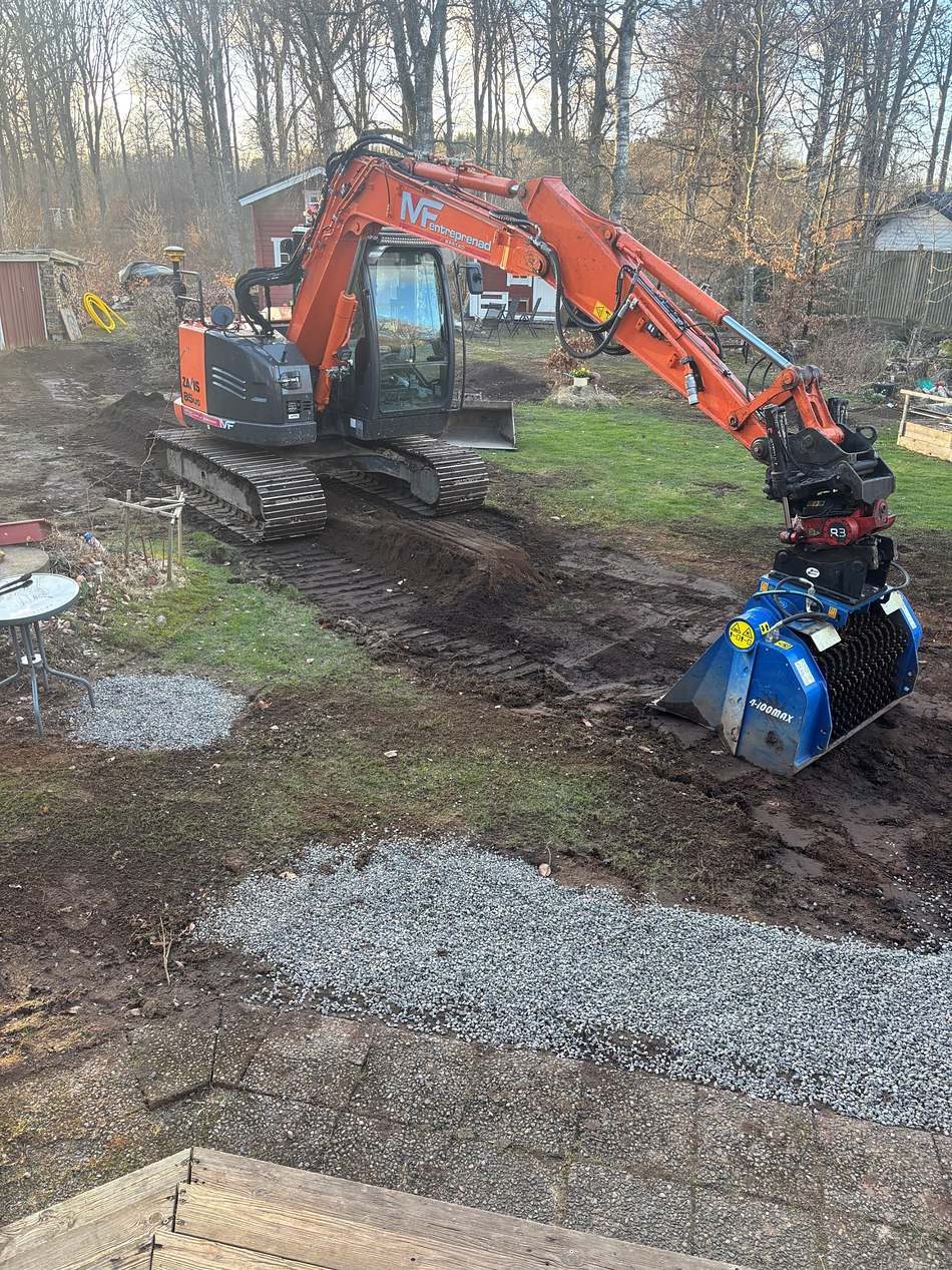 Grävmaskin med sorteringsskopa vid finplanering på villatomt