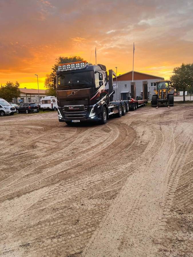 Lastbil med maskintrailer i skymning